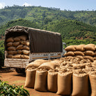 Truck loaded with sacks on a dirt road at Ethiopia Sidamo with green hills in the background